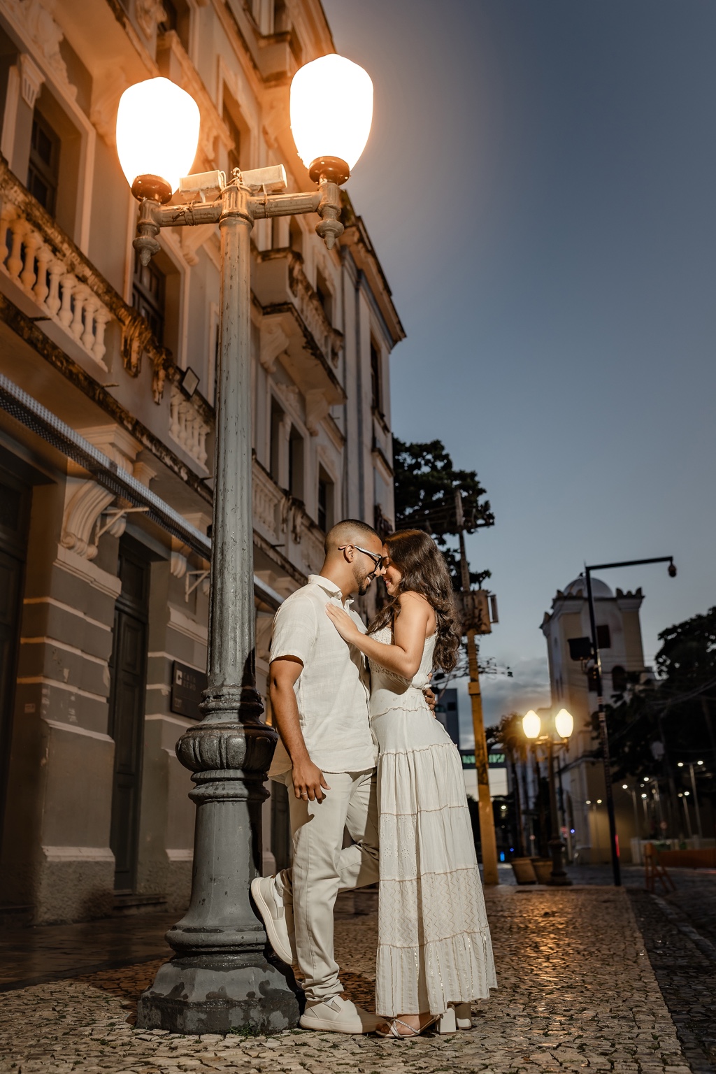 Maysa e Mateus sob a luz de um poste na rua histórica